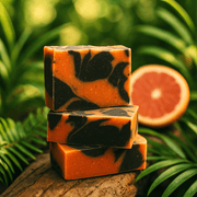 Grapefruit Palmarosa Bar Soap - Soap Boutique stacked on a log with citrus backdrop.