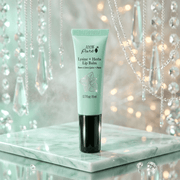 Green lip balm tube on a marble surface with decorative lights in the background