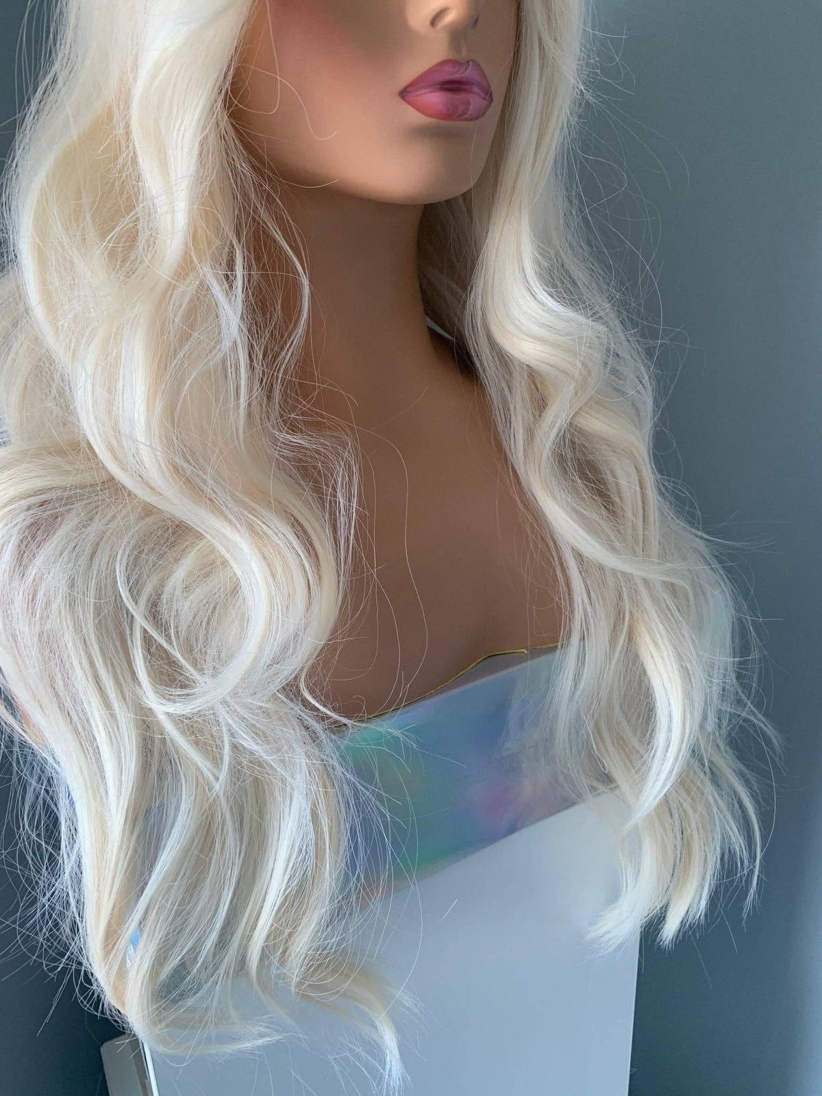 Gwen Long Blonde Layered Wig with Bangs displayed on a mannequin, featuring soft waves and shiny blonde locks.