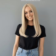 Hailey Silky Straight Blonde Wig displayed by a smiling model, showcasing sleek medium golden blonde hair.
