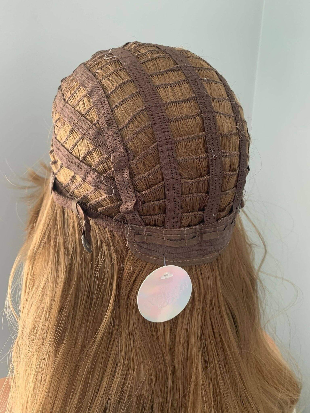Brown hairnet on a head with a plain background