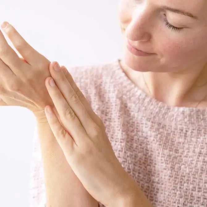 Woman applying Intensive Nourishing Balm to her hand for deep moisture and skin care.