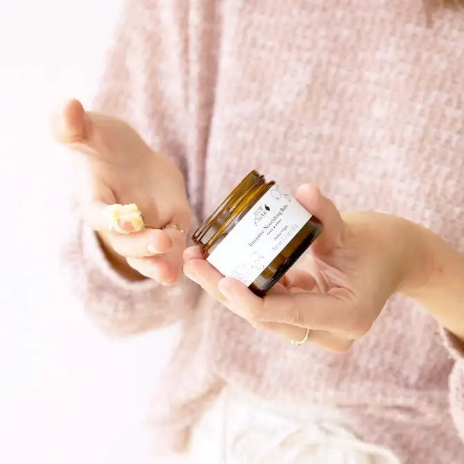Intensive Nourishing Balm jar in hands, showcasing its rich texture for dry skin treatment.