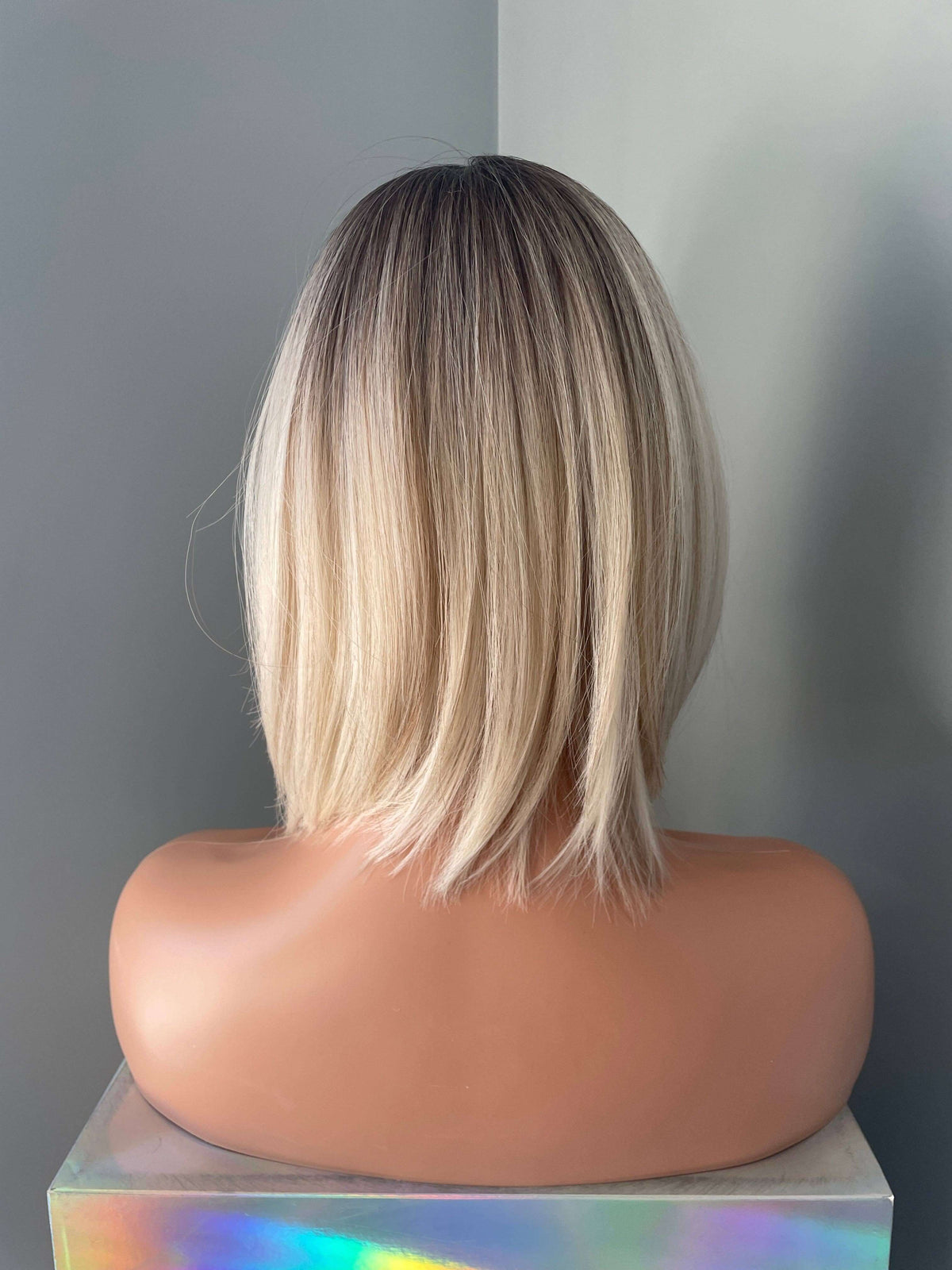 Back view of Katya Short Blonde Rooted Synthetic Bob Wig showcasing sleek ombre and shoulder-length style.