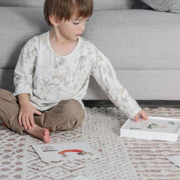 Child engaging with Yoga Flash Cards on a cozy rug, encouraging mindfulness and movement in learning.