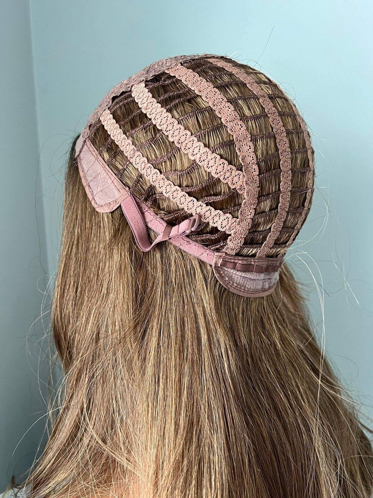 Back view of a wig cap with ribbons and natural brown curled hair, showcasing the structure of a Brown Curled Wig.