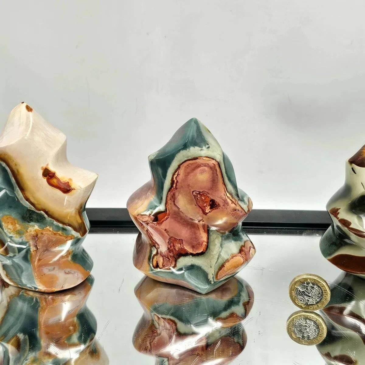 Three ceramic rocks with a reflective surface on a white background
