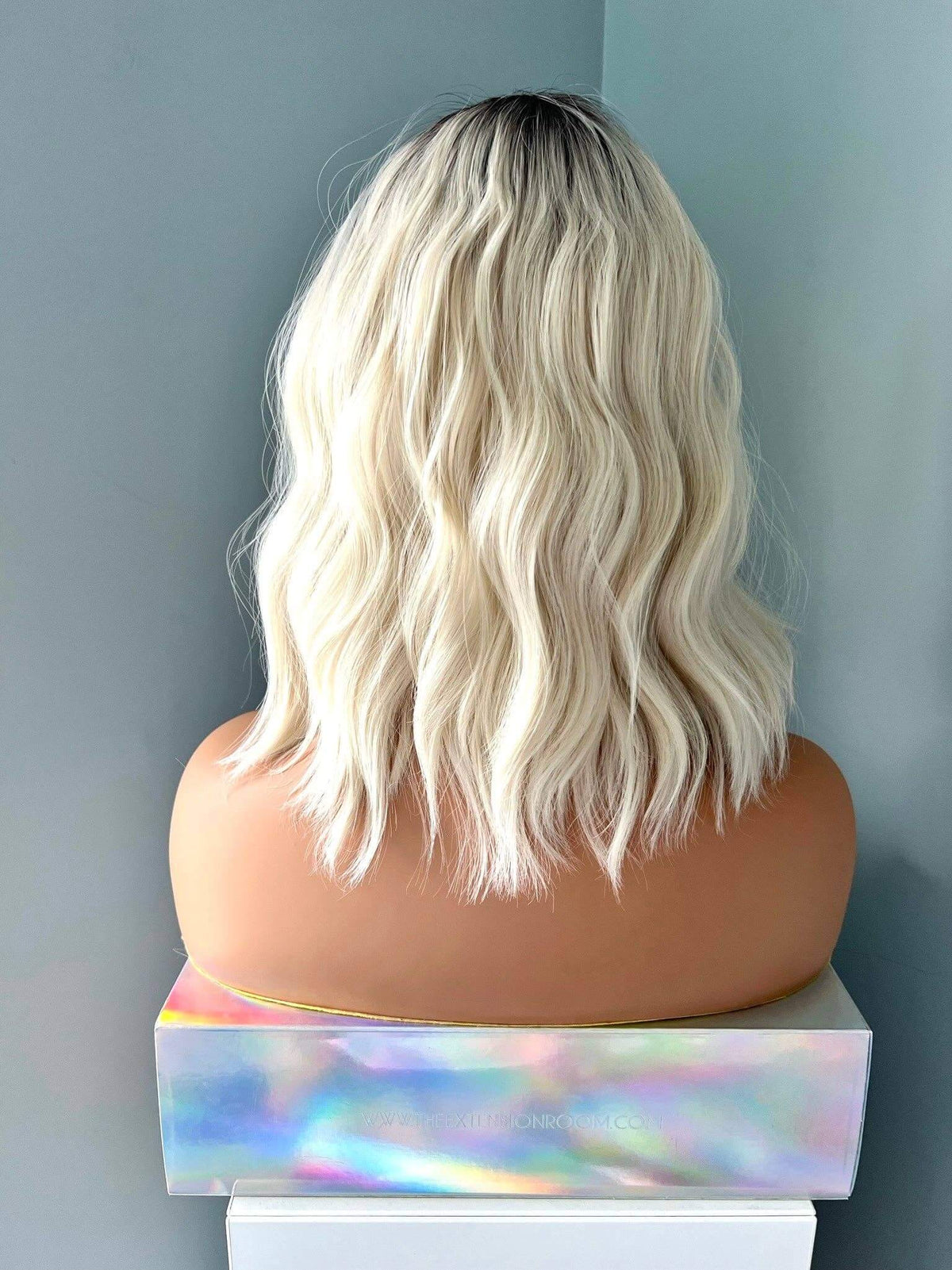 Back view of a Lilah Short White Blonde Body Wave Wig with Bangs, showcasing soft waves and a stylish cut.