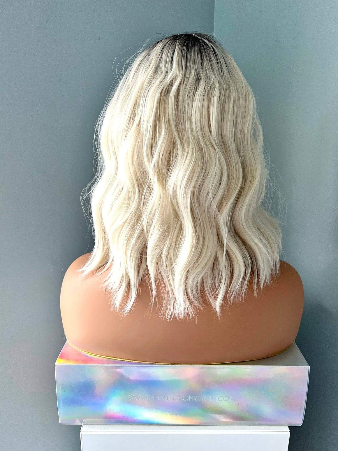 Back view of a Lilah Short White Blonde Body Wave Wig with Bangs, showcasing soft waves and a stylish cut.
