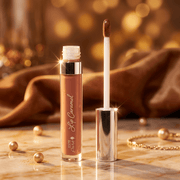 Lip balm with applicator on a wooden surface with a warm, blurred background