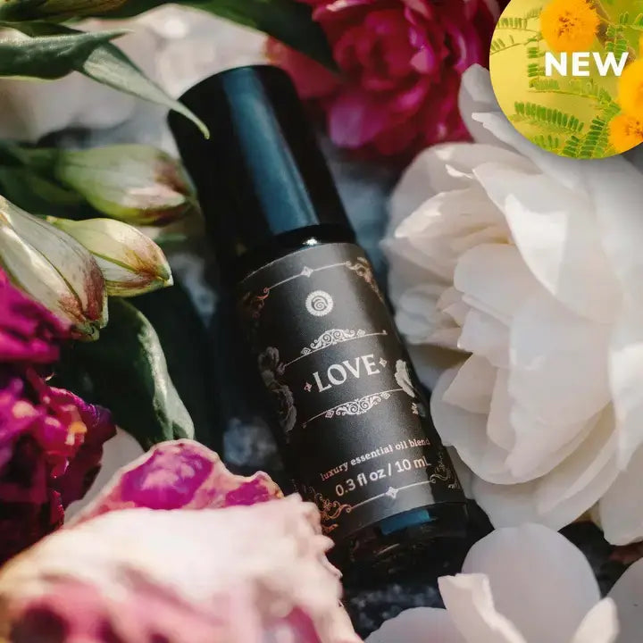 Love - Luxury Essential Oil Blend (10ml) - Annmarie Skin Care in floral setting with vibrant petals and new label.