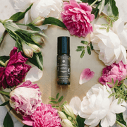 Love - Luxury Essential Oil Blend (10ml) - Annmarie Skin Care bottle surrounded by colorful flowers on a tray.