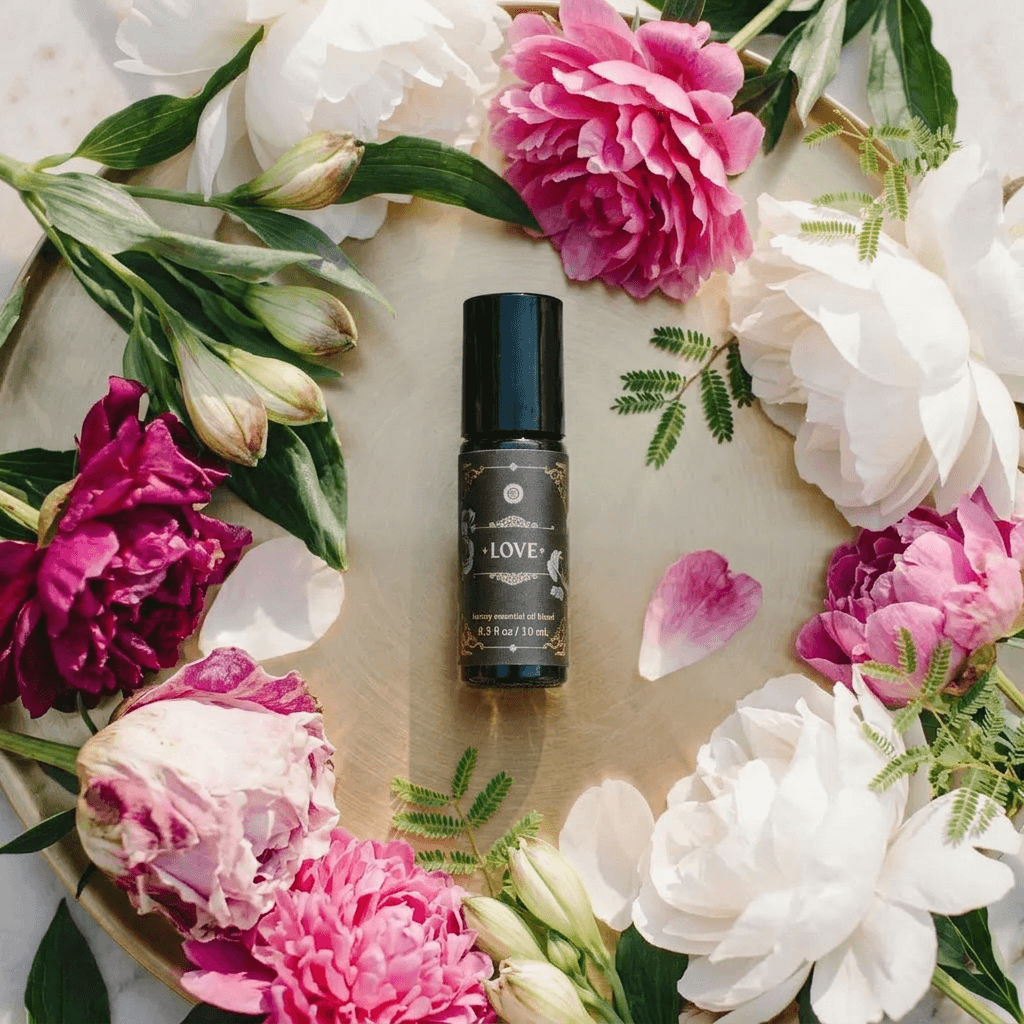 Love - Luxury Essential Oil Blend (10ml) - Annmarie Skin Care bottle surrounded by colorful flowers on a tray.