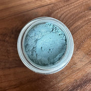 Jar of blue powder on a wooden surface