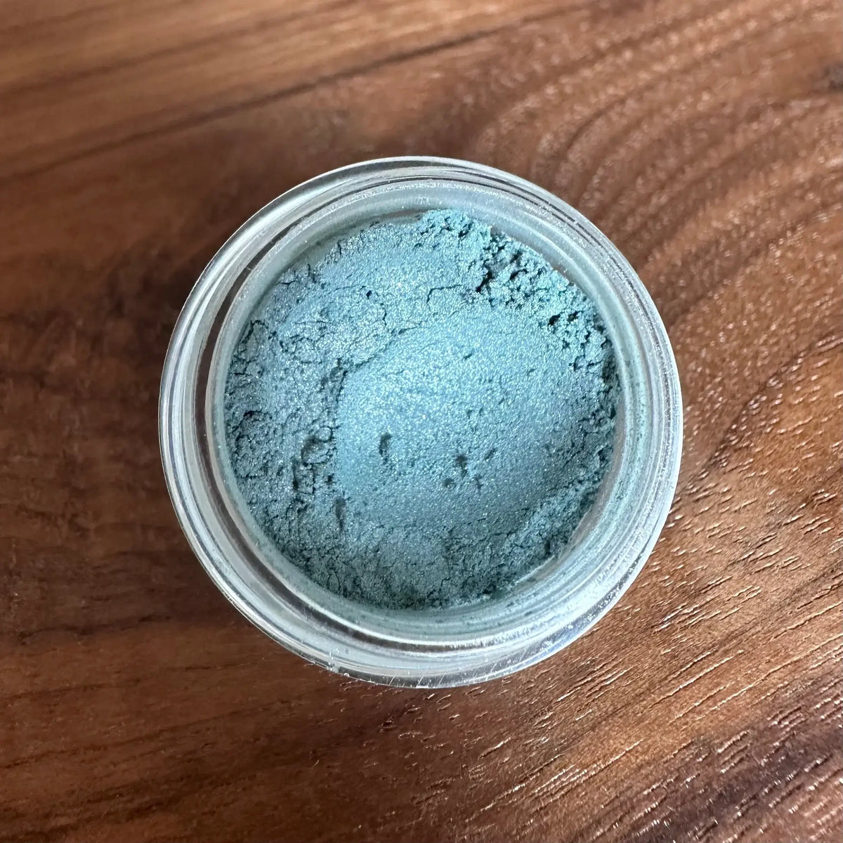 Jar of blue powder on a wooden surface