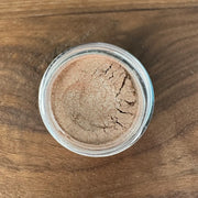 Jar of brown powder on a wooden surface