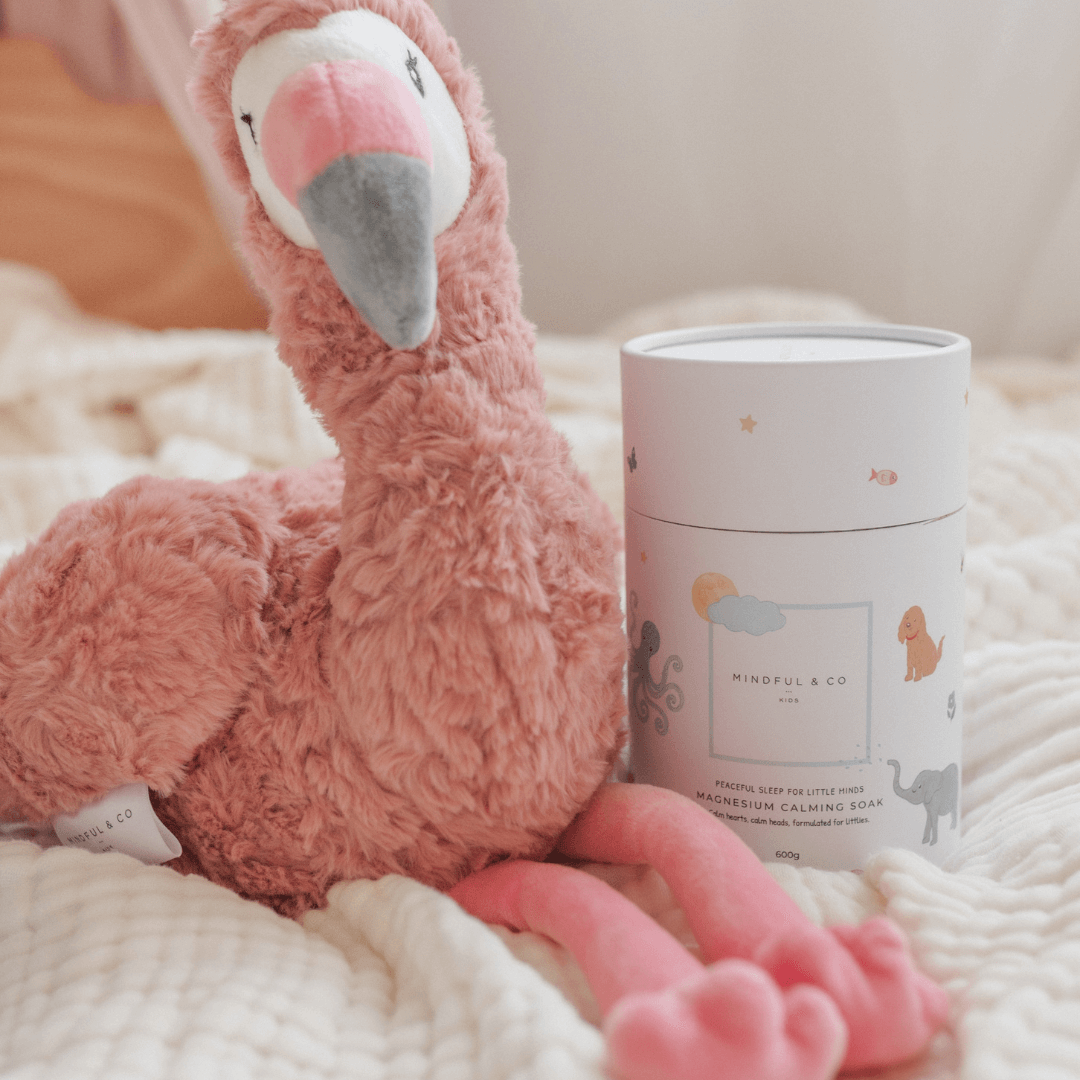 Image of a plush flamingo beside Magnesium Calming Soak 600g, promoting relaxation for children.