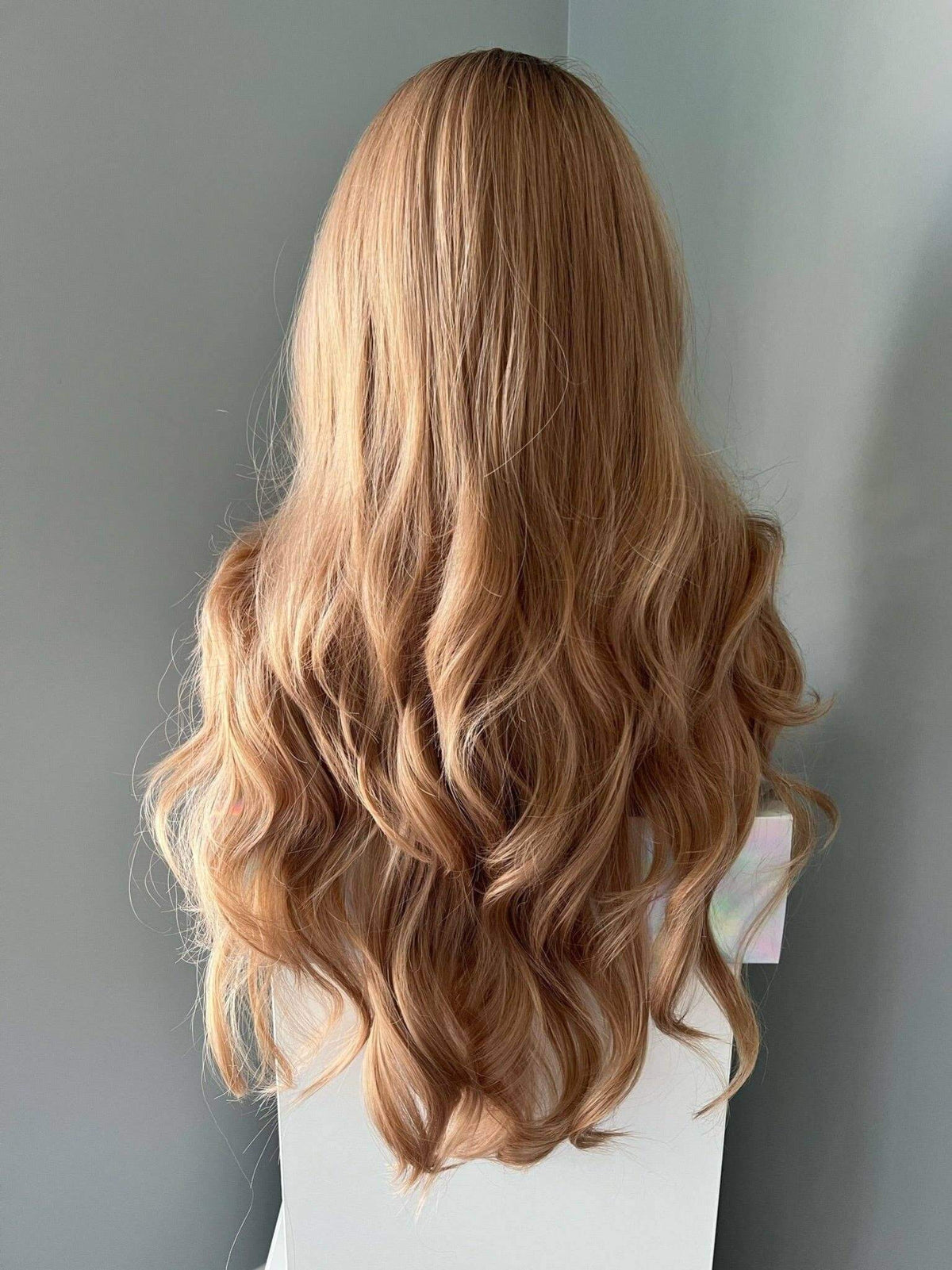 Long honey blonde curled wig with soft waves, showcasing natural beauty and effortless style.
