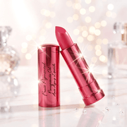 Maroon lipstick with reflective case on a sparkling background