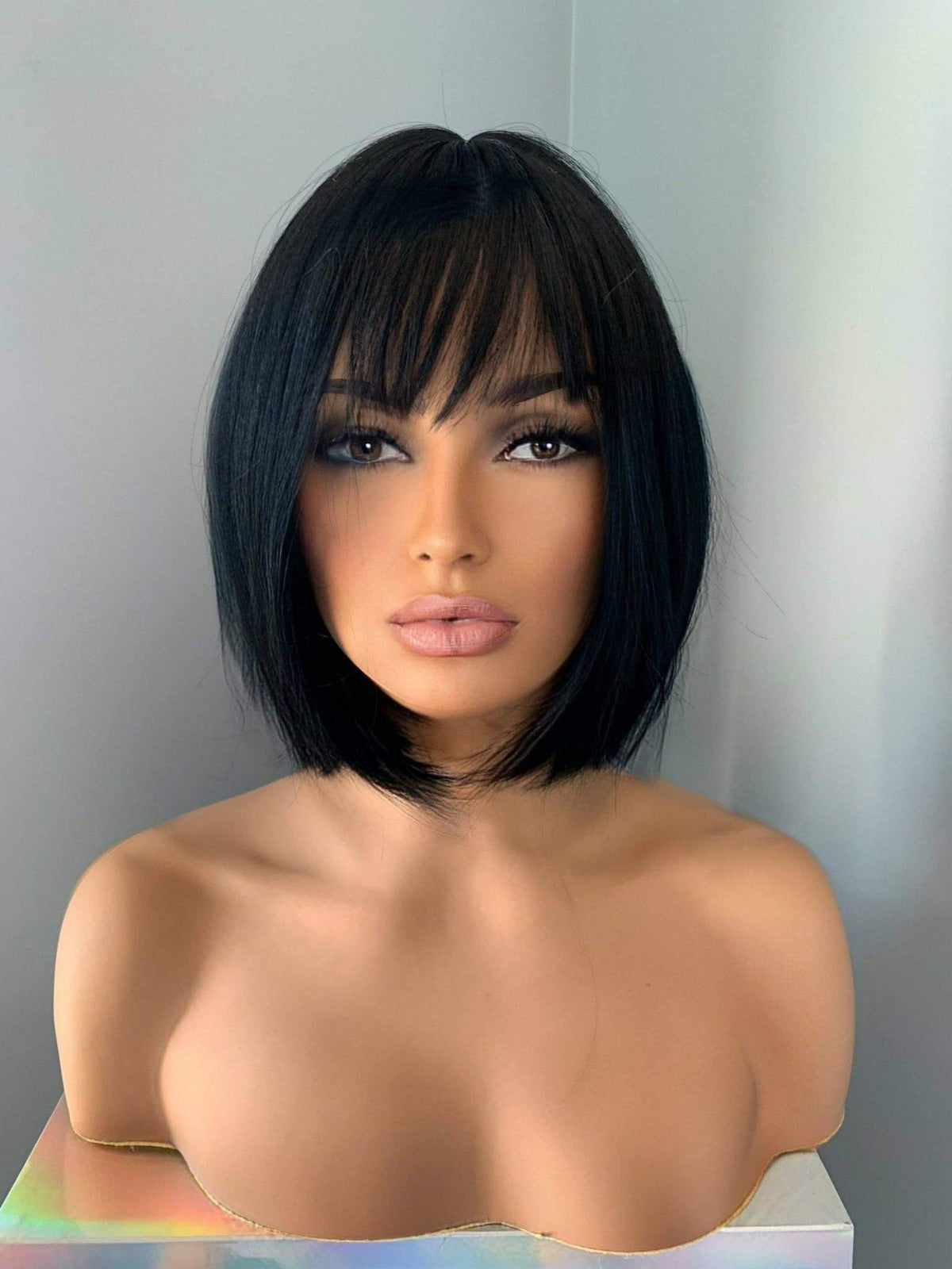 Mannequin head with a black bob wig on a white background
