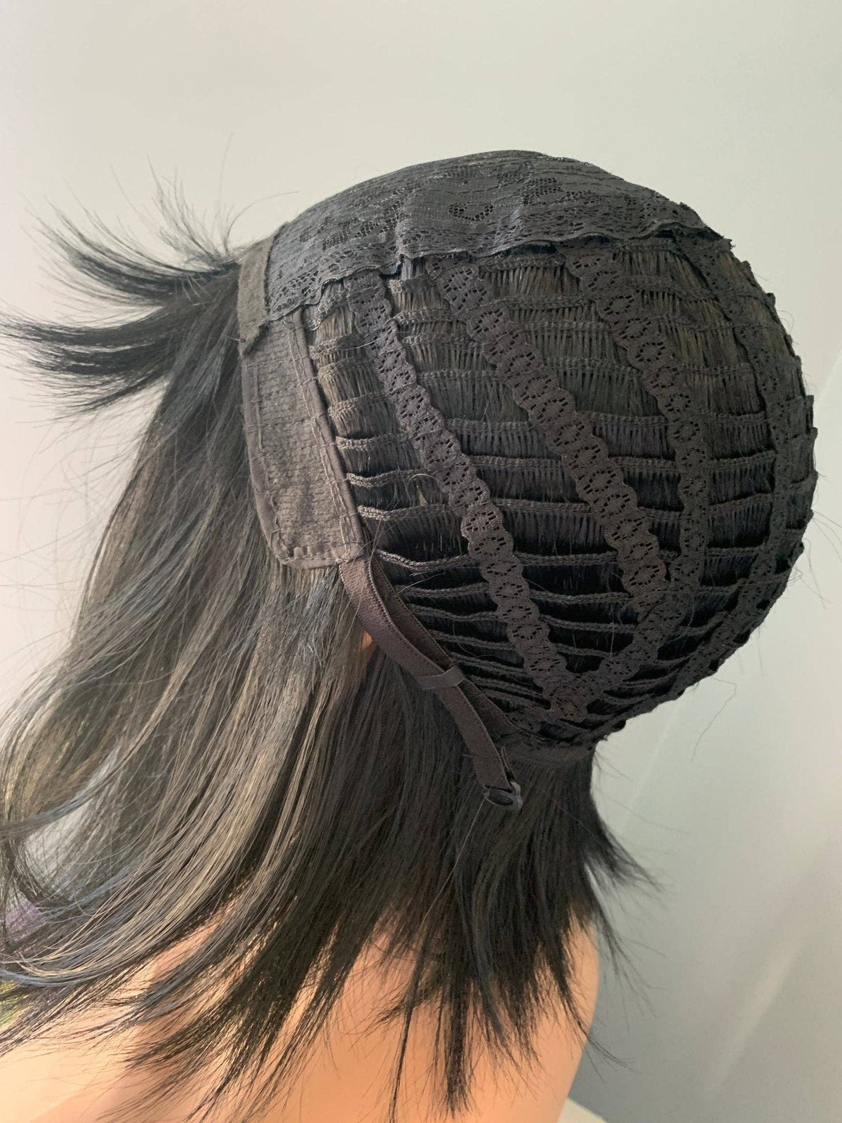 Black lace front wig with a ponytail on a plain background
