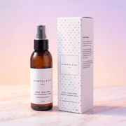 Brown bottle and white box of Mindful & Co Aromatherapy Mist on a light background