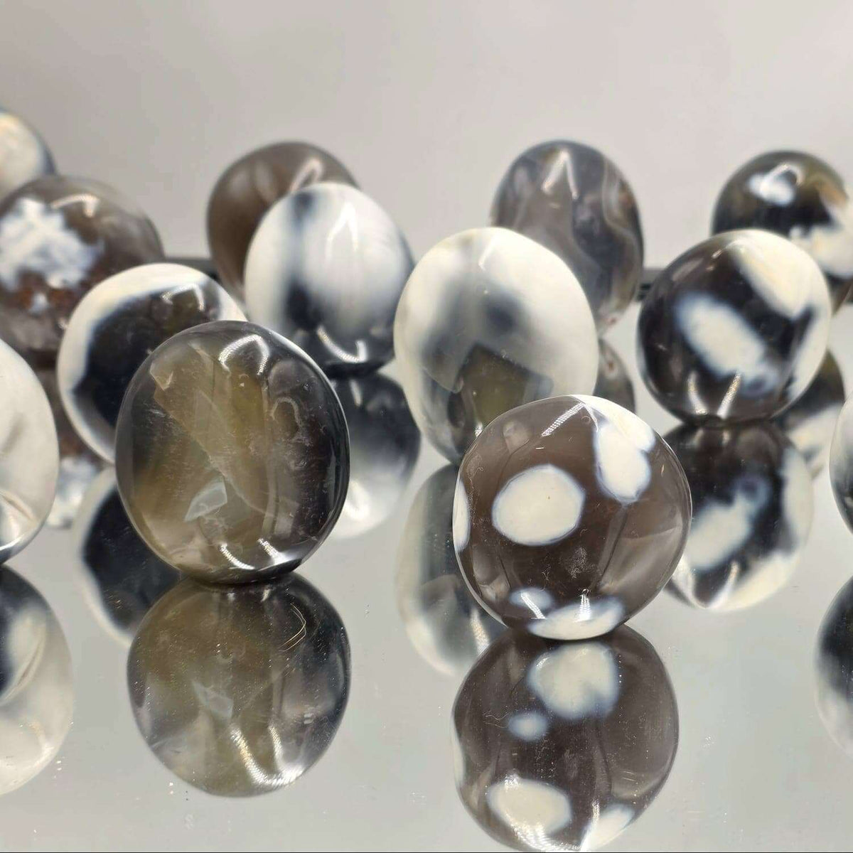 Black and white marbled beads on a reflective surface