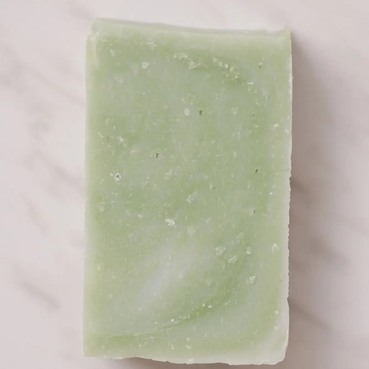 Green soap bar on a light beige background