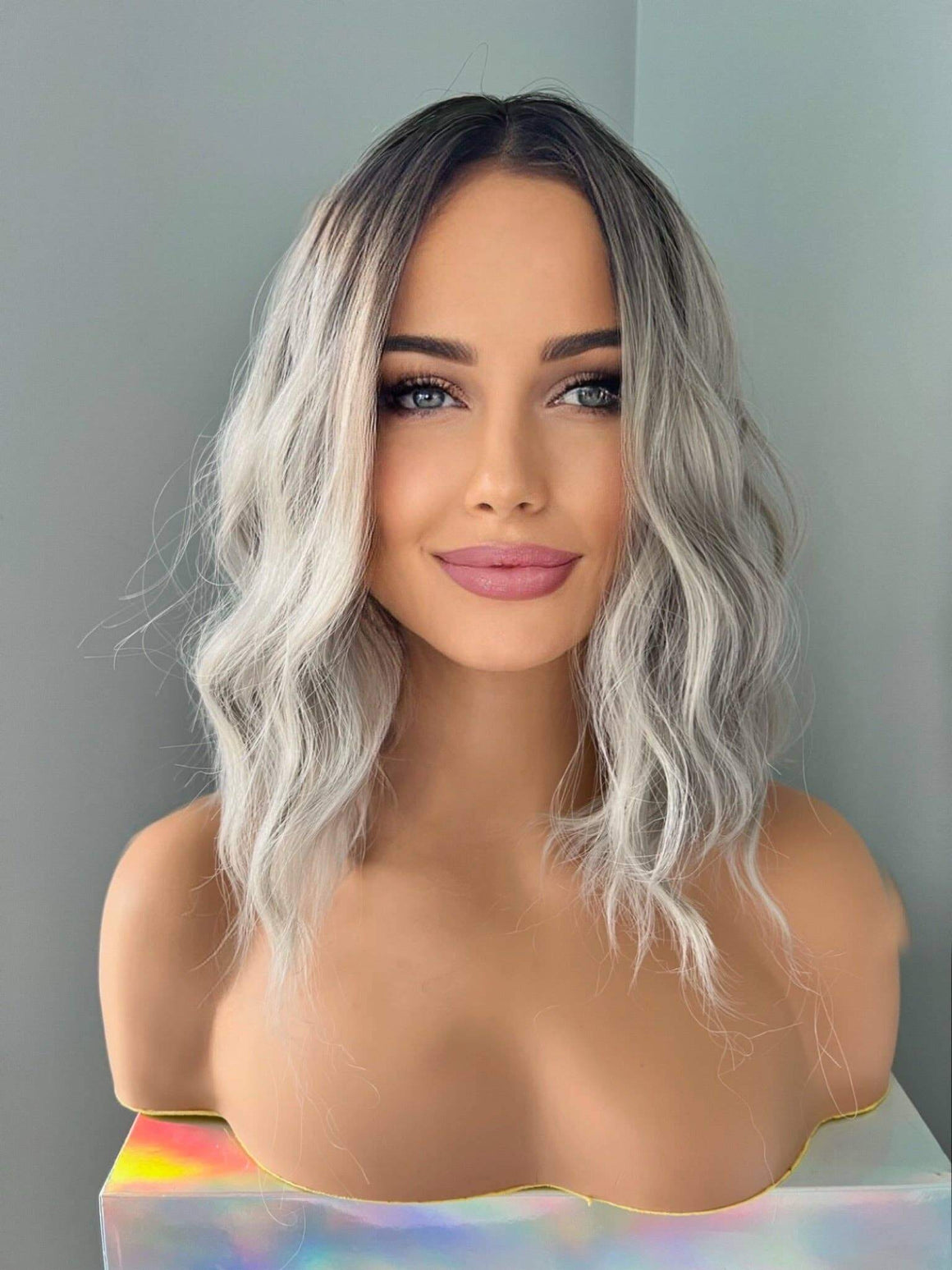 Woman with wavy, shoulder-length hair against a plain background