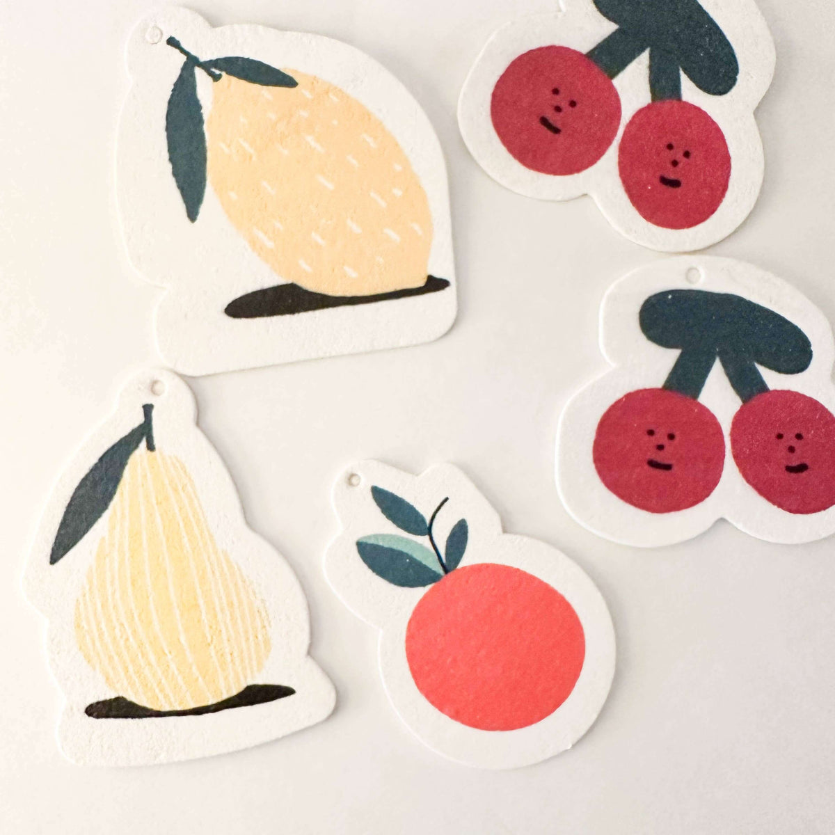 Set of fruit-themed stickers including lemons, pears, and cherries on a light background