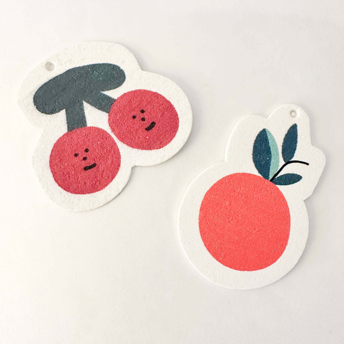 Two cartoon-style fruit stickers on a white background