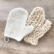 Two natural fiber sponges on a wooden surface