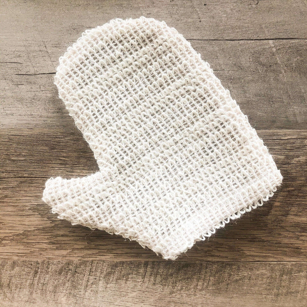 White textured scrubber on a wooden surface
