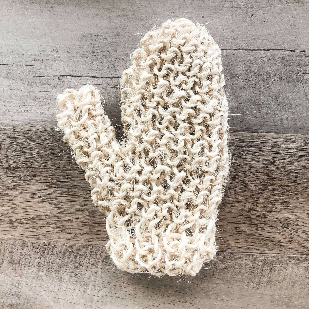 Knitted white cactus-shaped object on a wooden surface