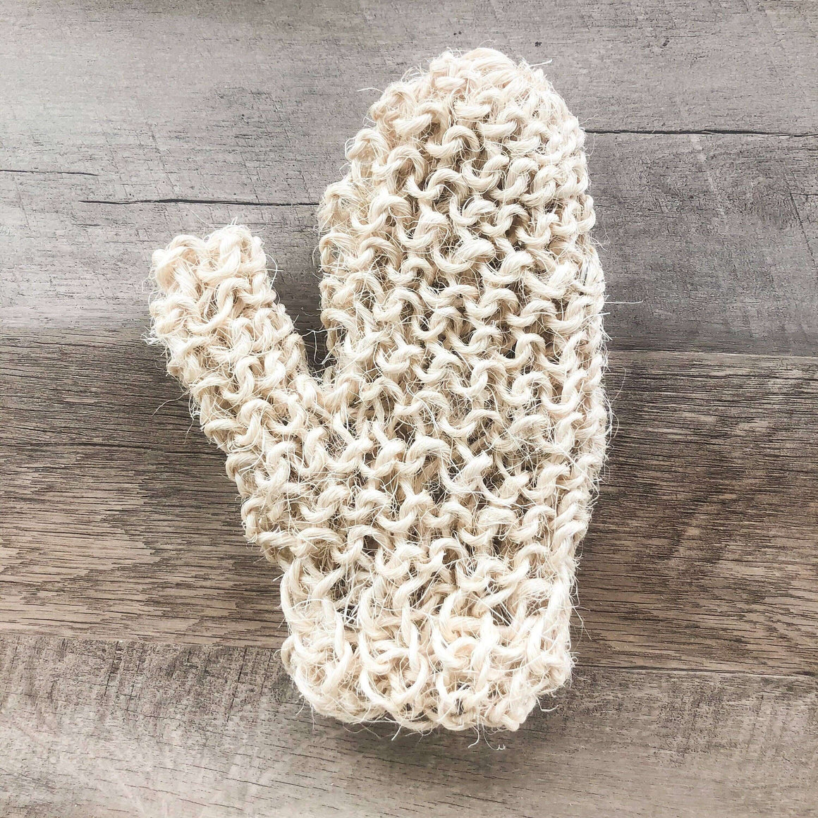Knitted white cactus-shaped object on a wooden surface