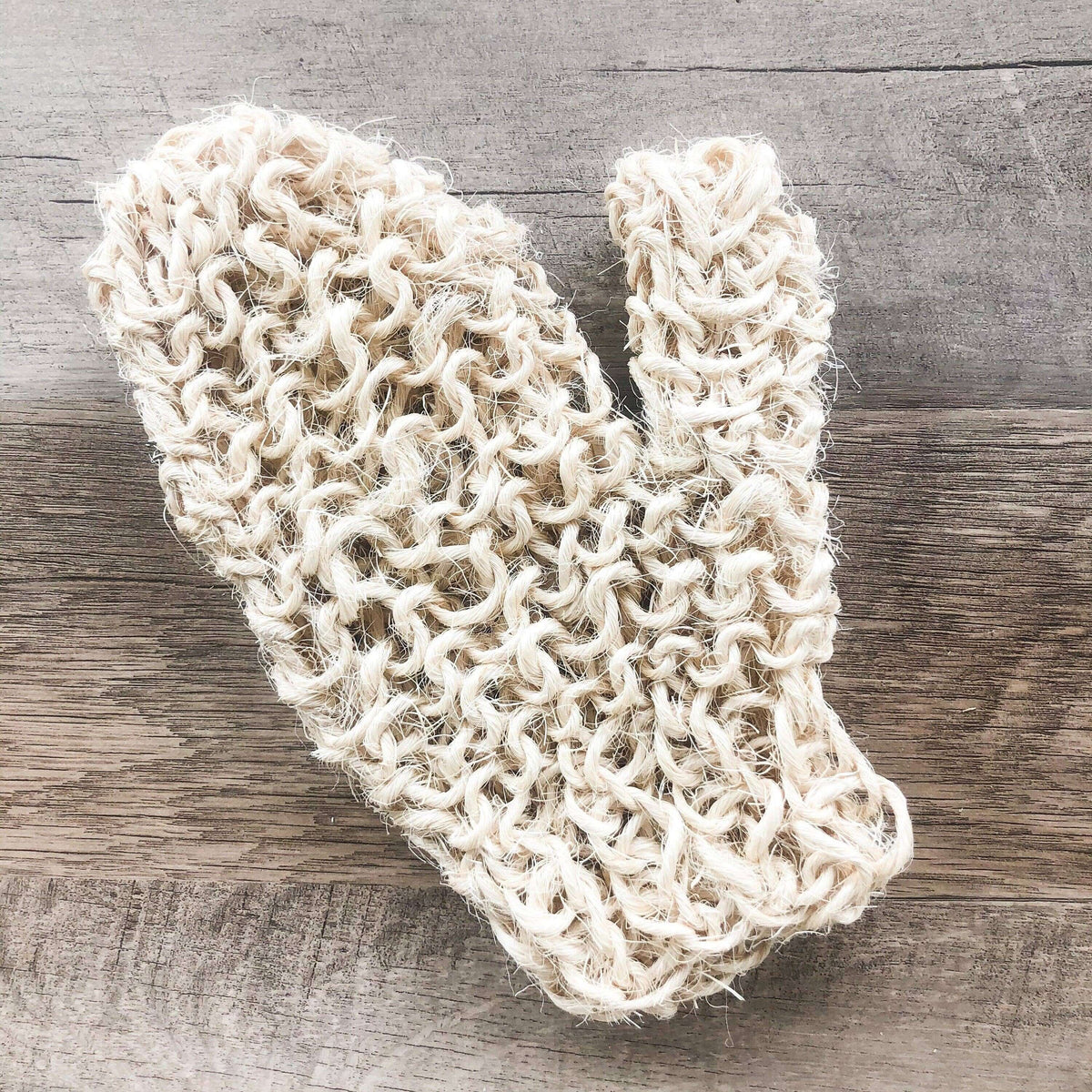 Knitted beige scarf on a wooden surface