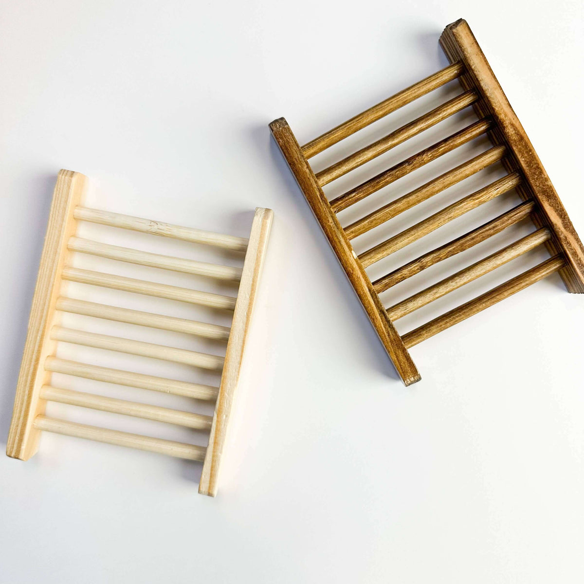 Two wooden soap dishes on a white background