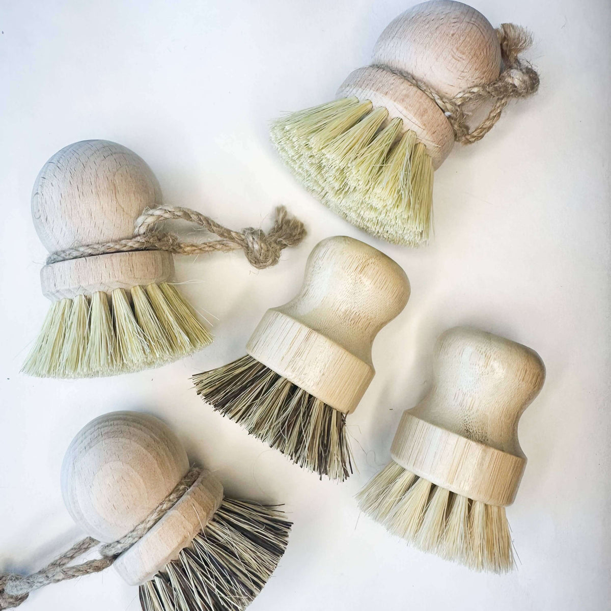 Set of wooden cleaning brushes with bristle heads on a white background