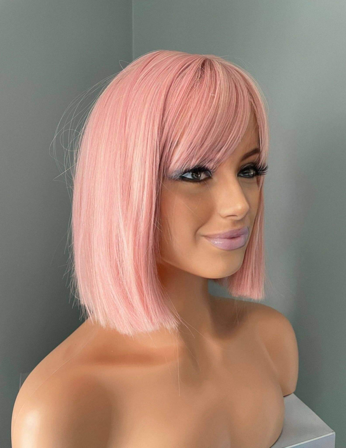 Nia Short Baby Pink Bob Wig showcasing soft pastel pink tones and full bangs on a mannequin head.