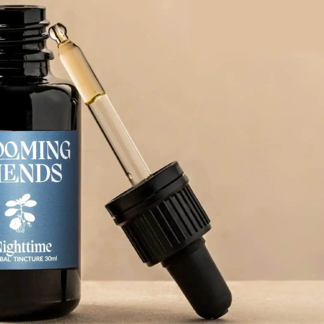 Bottle of 'Booming Tendens' tincture with dropper on a beige background