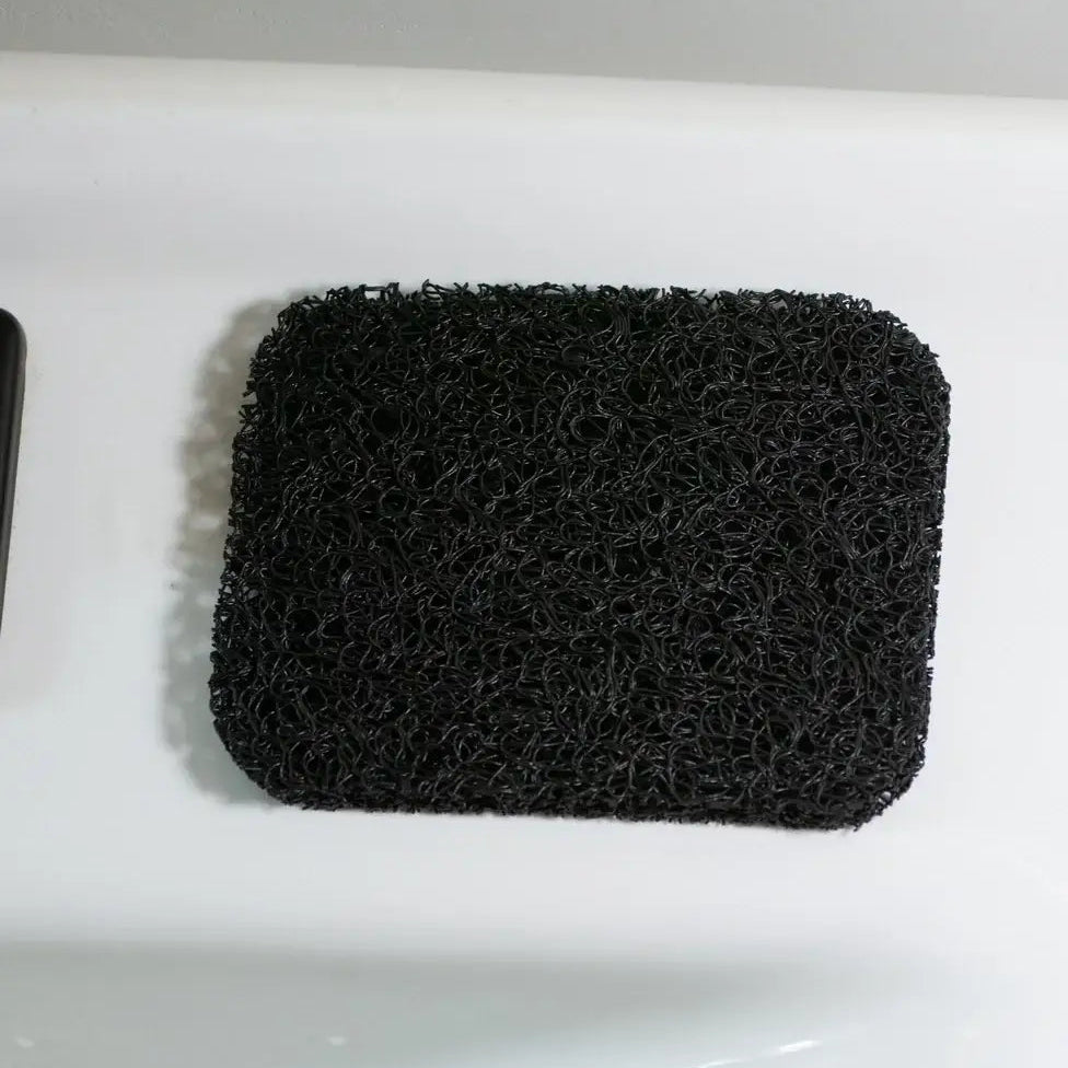 Black sponge on a white surface with a gray background