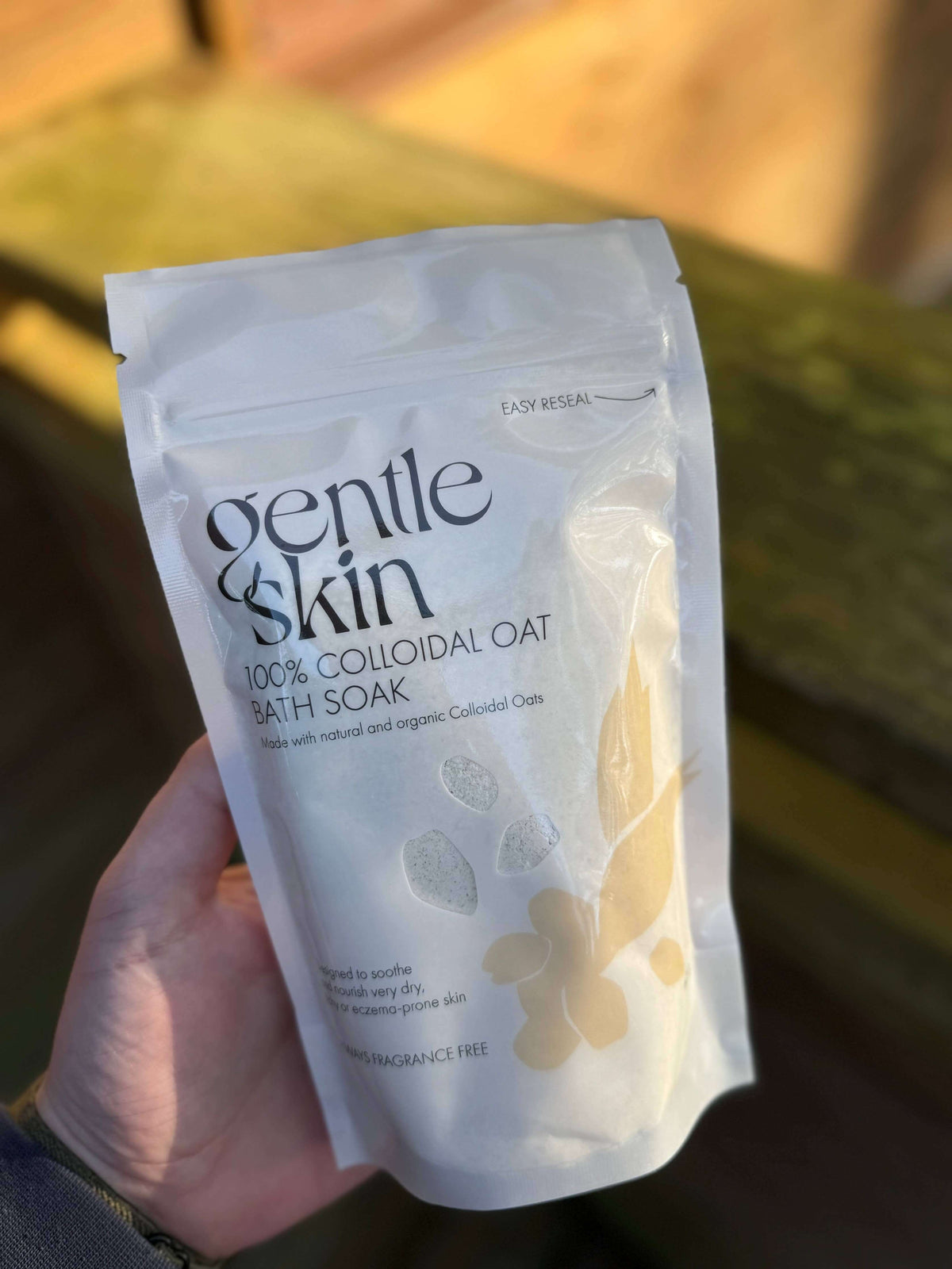 100% Organic Colloidal Oat Bath Soak packaging held in hand, perfect for soothing sensitive skin.