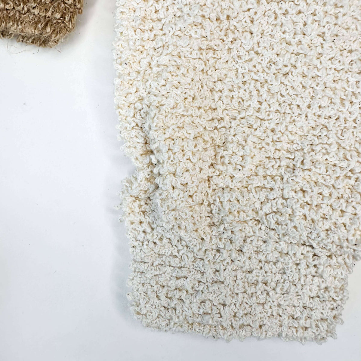 Close-up of a textured beige carpet on a white background