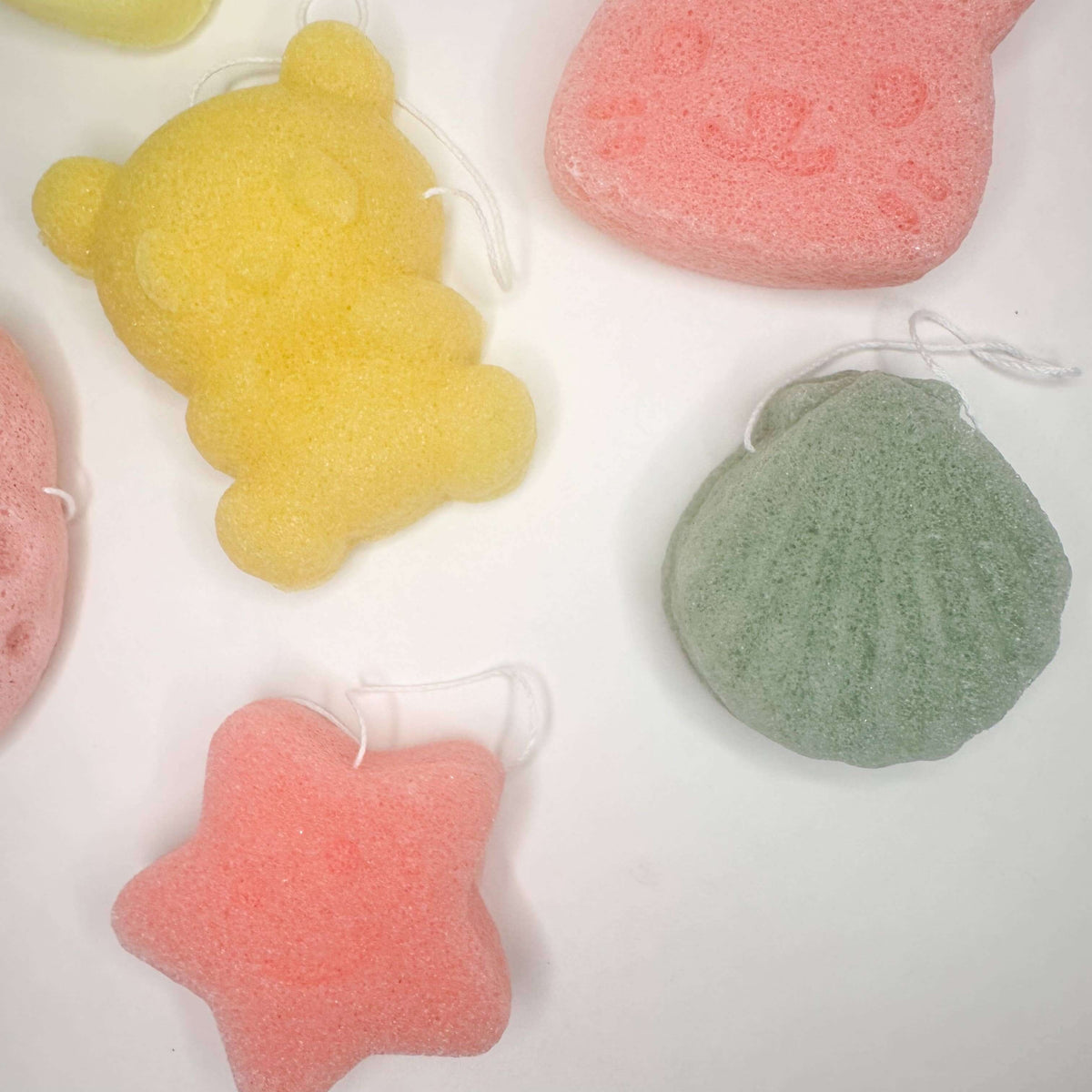 Colorful Natural Organic Konjac Facial Sponges in cute shapes like bear, star, and shell.