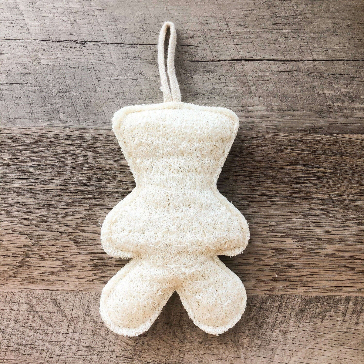 White plush toy hanging on a wooden surface