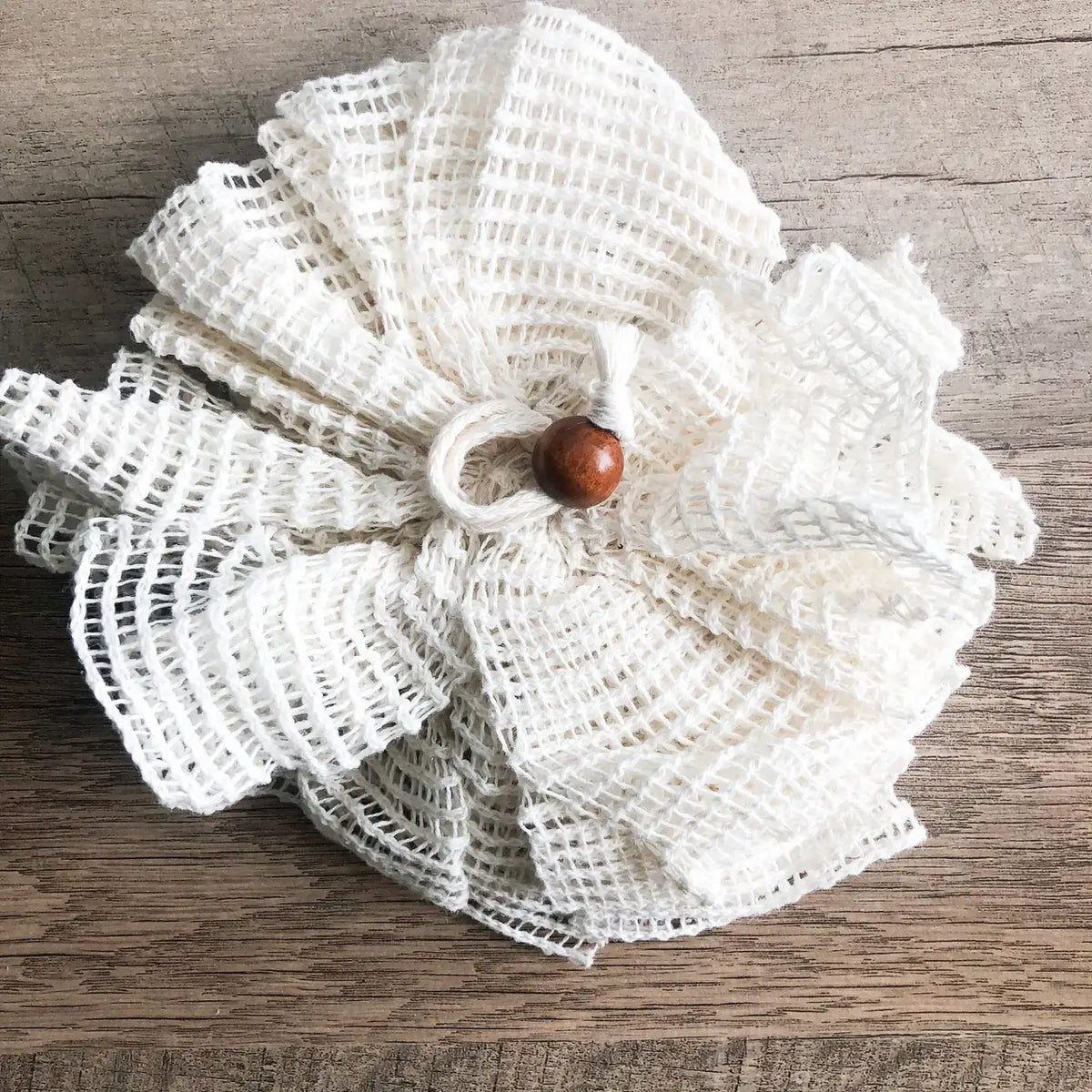 White textured flower with a brown center on a wooden surface
