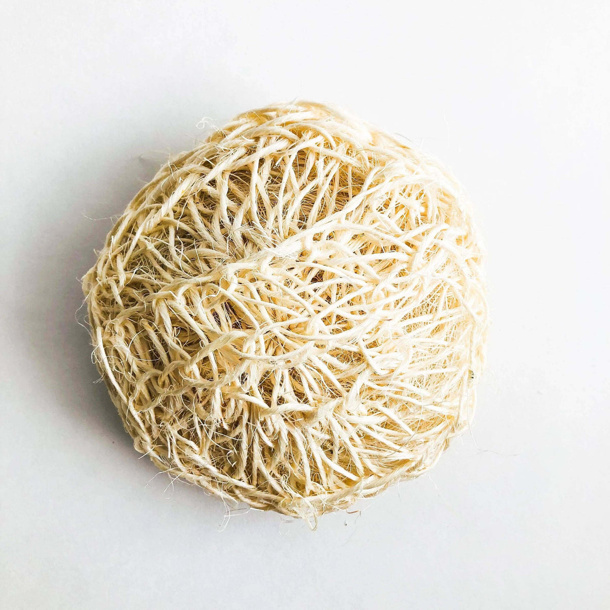 Round ball of natural fiber on a white background