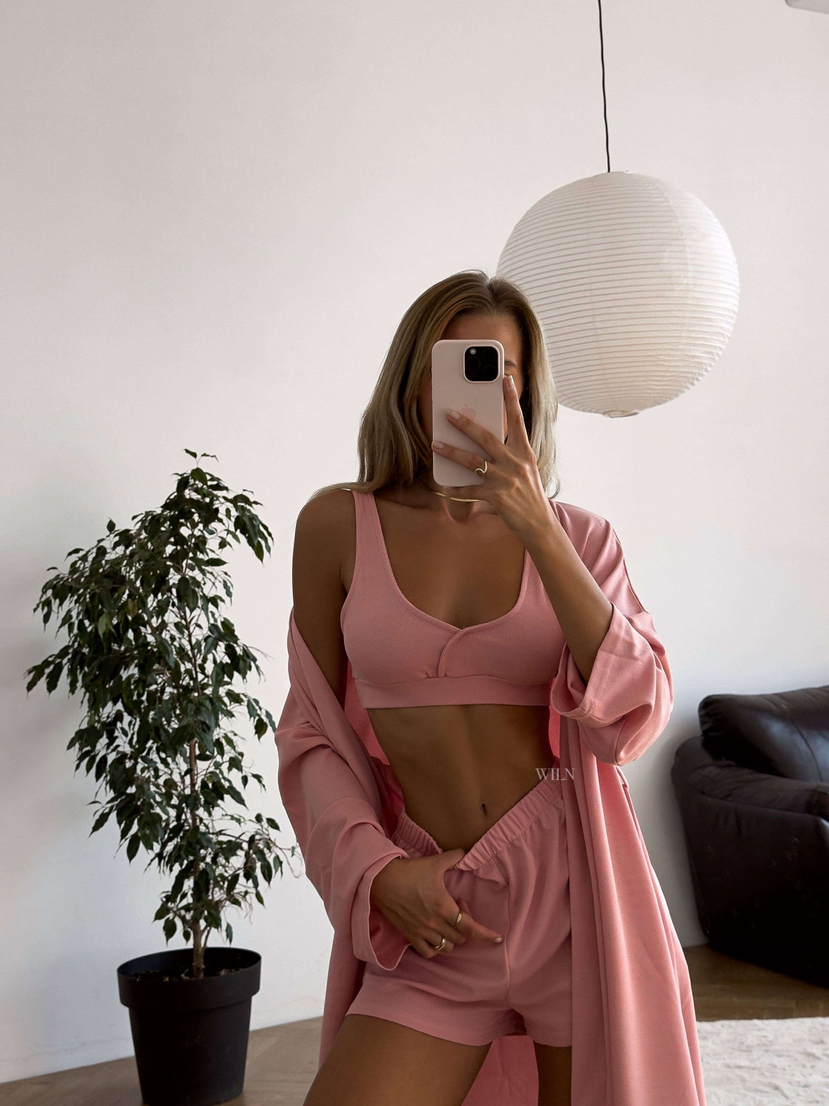 PEACE 3 Piece lounge suit - Pink worn by a model in a bright, minimalist room with plants.