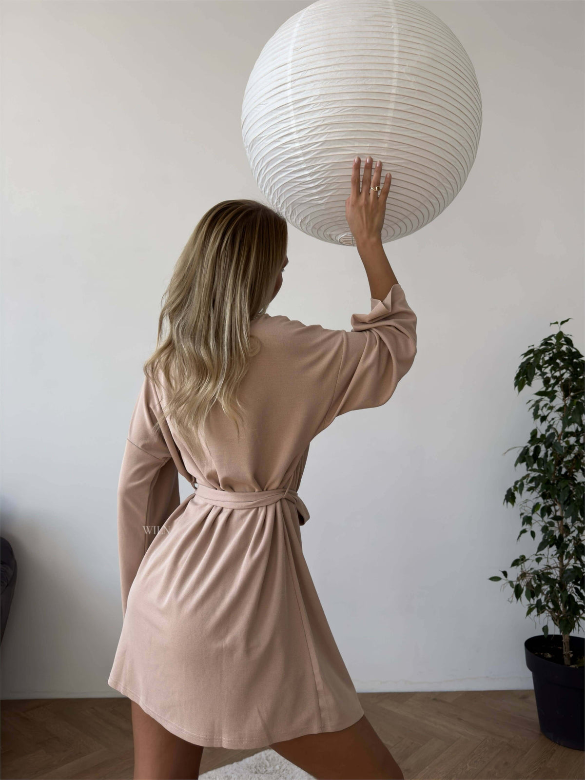 Model wearing the PEACE Three-Piece Lounge Set in Mocha Latte, holding a lantern in a stylish indoor setting.