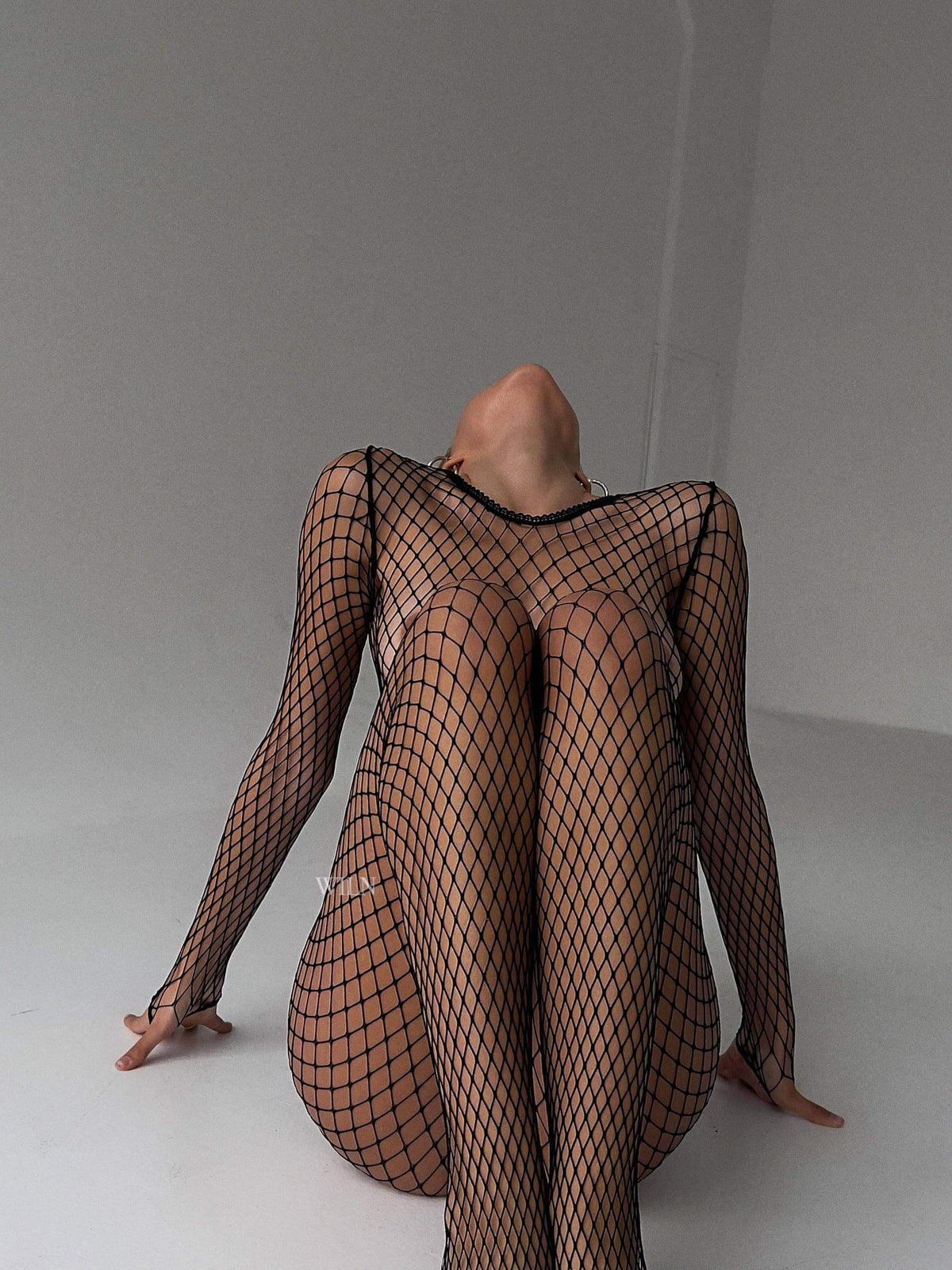 Model wearing PREY Fishnet Bodysuit, showcasing a flattering black fishnet design for confidence and style.